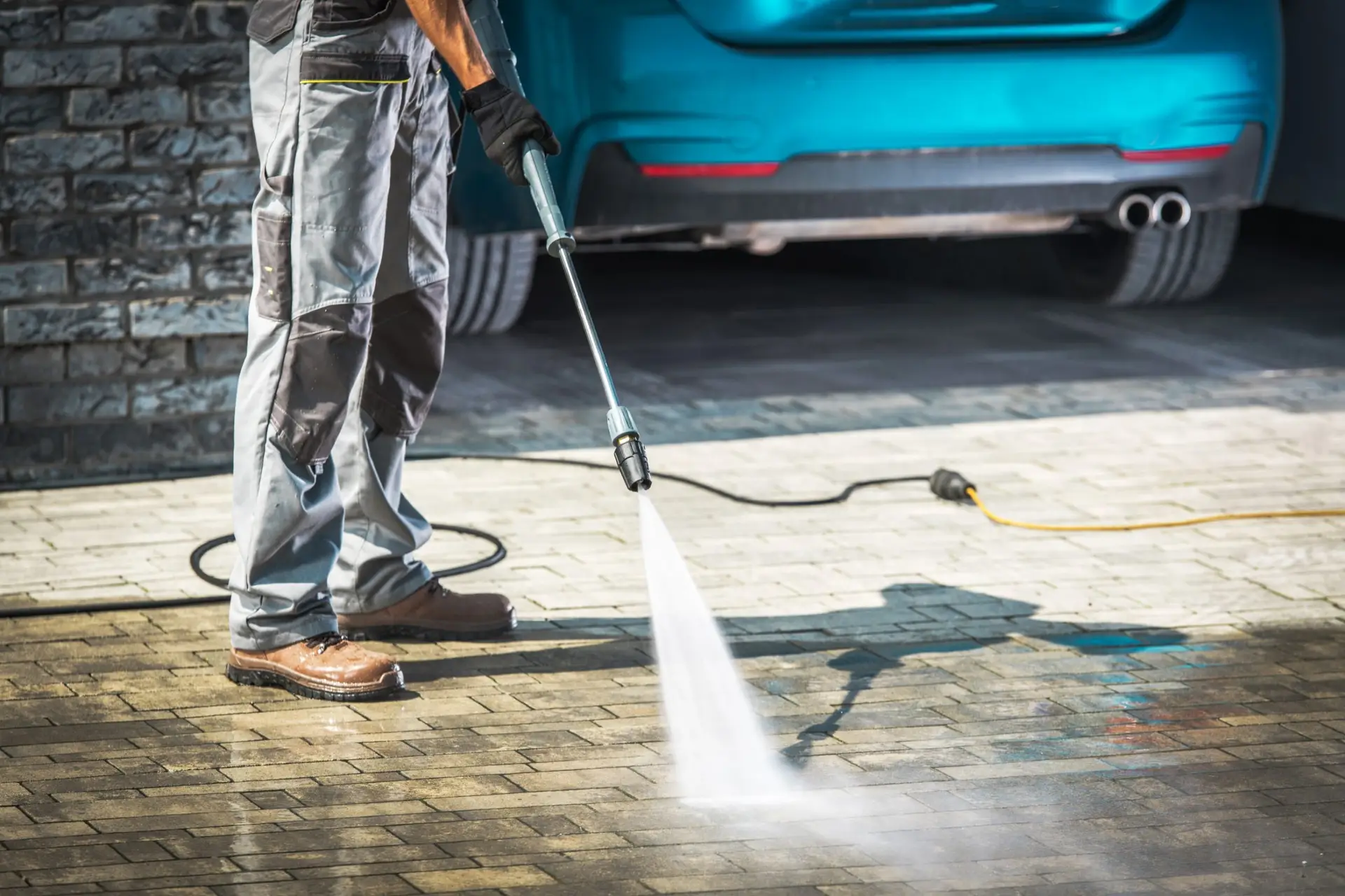 man pressure washing driveway